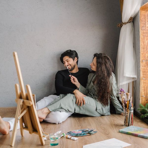 Smiling person meditating on a yoga mat with soft morning light filtering through a window.